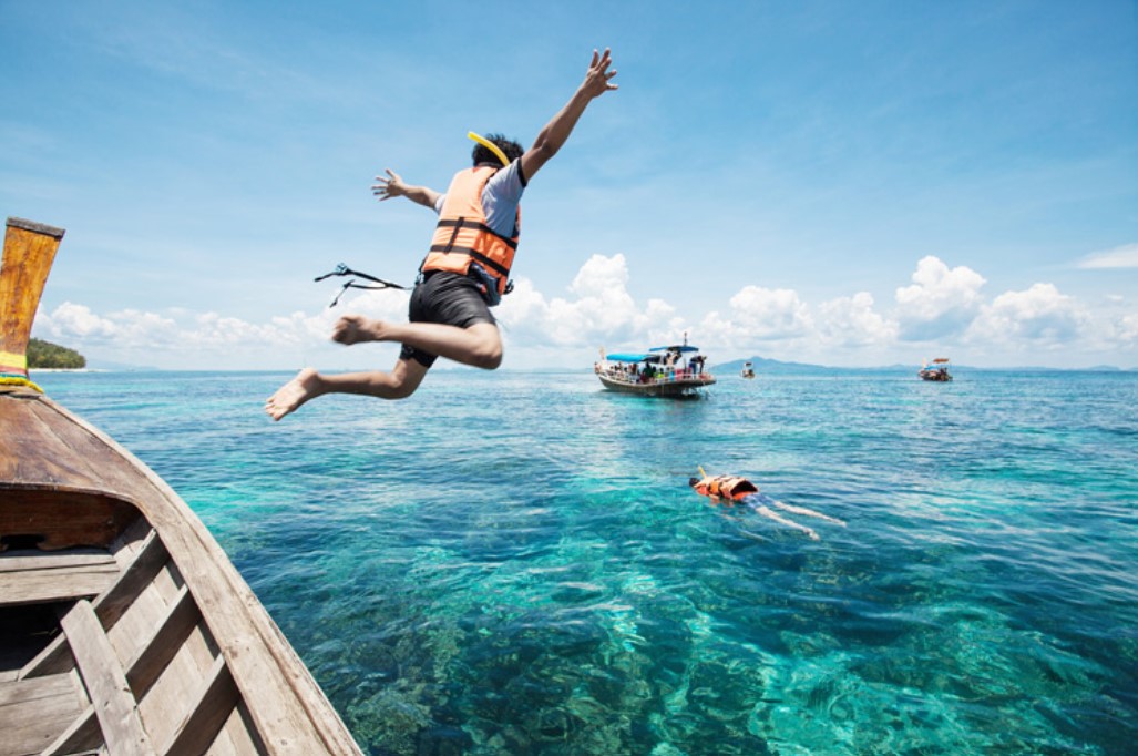 Thailand - guy jumping off a boat to snorkel