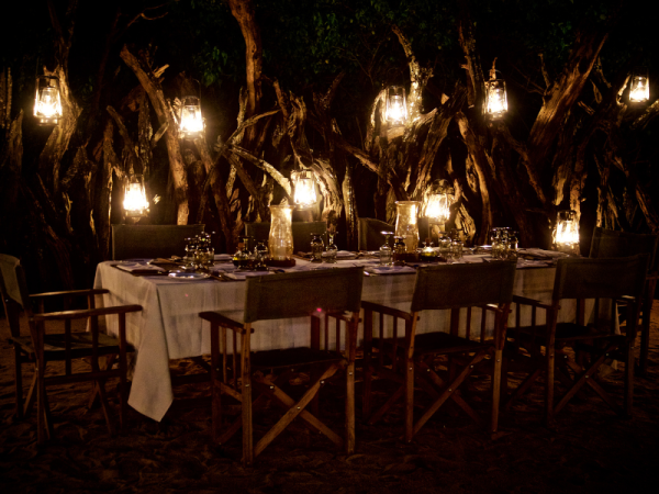 safari boma dining set up with low lit candles and lamps
