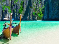 Famous scenic Maya Bay beach at Ko Phi Phi Leh Island with two traditional longtail taxi boats mooring and steep limestone hills in background Thailand part of Krabi Province Andaman Sea iStock 932253414 banner