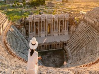 Hierapolis ancient city Pamukkale Turkey a young Asian woman with a hat watching the sunset by the ruins Unesco site during summer iStock 1421262662 banner