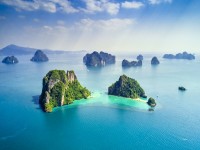 Surrounding Islands of Koh Yao Noi Phuket Thailand green lush tropical island in a blue and turquoise sea with islands in the background and clouds with sun beams shining through drone aeriashutterstock 1107675575