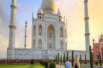 Taj Mahal historic white marble mausoleum at sunrise with view of tourist couple enjoying the view at Agra India. Taj Mahal is a UNESCO World Heritage site iStock 1249327701