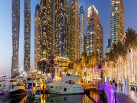 Dubai Marina and Harbour skyline architecture wealth luxury travel with yacht boat at night panorama in United Arab Emirates modern banner iStock 1364234964