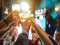 Group of happy friends drinking and toasting beer at brewery bar restaurant Friendship concept with young people having fun together at cool vintage pub Focus on middle pint glass iStock 962573364