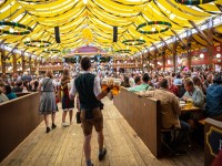 Munich Germany Oktoberfest Waiter in tyrolean costume holding beers tent interior background iStock 1133515464