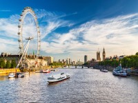 View of Westminster Parliament Big Ben and London Eye with Thames and tourist ship in foreground on a sunny summer afternoon iStock 952375942 1
